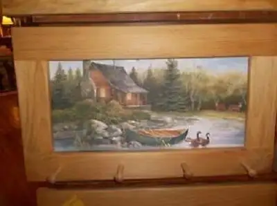 This peg-board shows a log cabin with a canoe pulled up on shore at the back. There can also be seen...