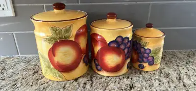 This is a used, three-piece ceramic canister set featuring a vibrant fruit design. The set is in goo...