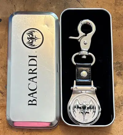 This is a limited-edition, Bacardi Rum "Bat-Signal" flip top pocket watch keychain in excellent cond...