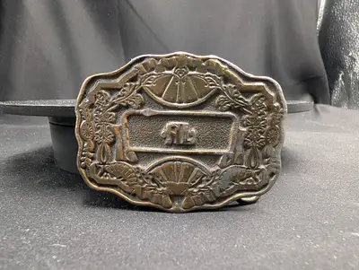 This ia a vintage brass belt buckle made by Oden, Inc., featuring an ornate design and an inscribed...