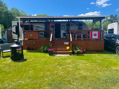 This beautiful 2019 Coachmen Freedom Express 29 ft RV and well built, newly stained deck are set up...