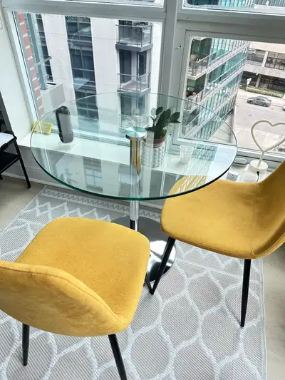 Round glass dining table and 2 yellow chairs. Will easily fit 4 chairs Hardly used. Like new! Willin...