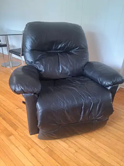 Sink into relaxation with this black leather recliner, perfect for any living space needing a touch...