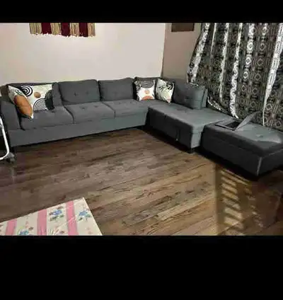 This is a brand new grey sectional sofa, perfect for a living room and features a chaise lounge for...