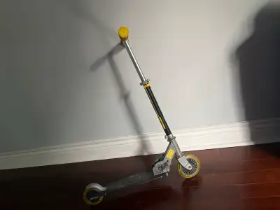 Used kid's scooter. Silver and black frame. Yellow grips and wheels. Good condition.