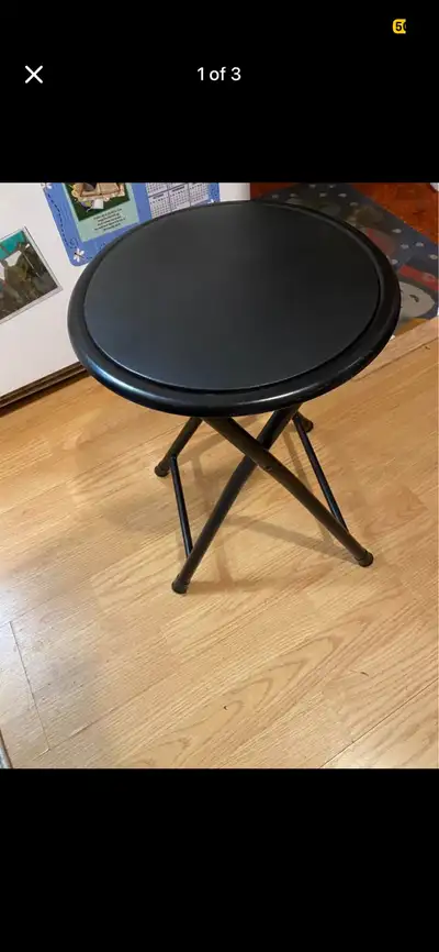 This is a folding stool with a black padded seat and black metal frame. It's in used condition but i...