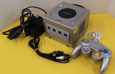 Console Nintendo GameCube argent en bonne condition et fonctionnelle. Comprends Manette générique et...