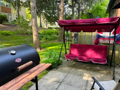 RED PATIO SWING WITH EXTRA CUSHIONS AND A ROUND OUTDOOR RUG, View more