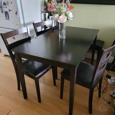 Solid wood dining table with three cairs and a sitting bench.