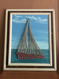 Vintage hand-made string art sailboat on lake