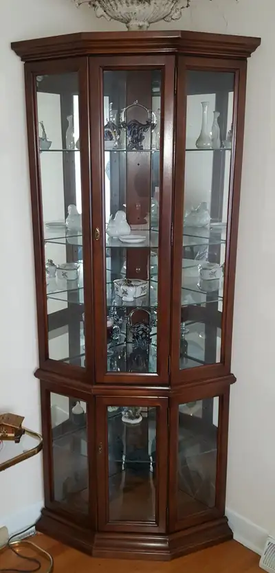 Corner curio cabinet with glass shelves. Great for displaying your figurines, nic nacks, etc. In ver...