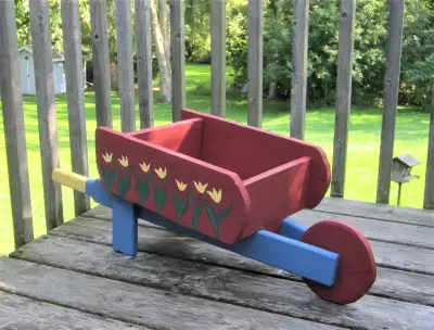 Cedar wood wheelbarrow planter. Hand painted tulips on both sides of wheelbarrow. Length from handle...