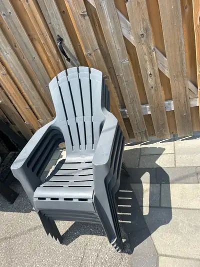 These are 4 used dark grey Adirondack-style plastic chairs. $15 each of $50 for all 4.