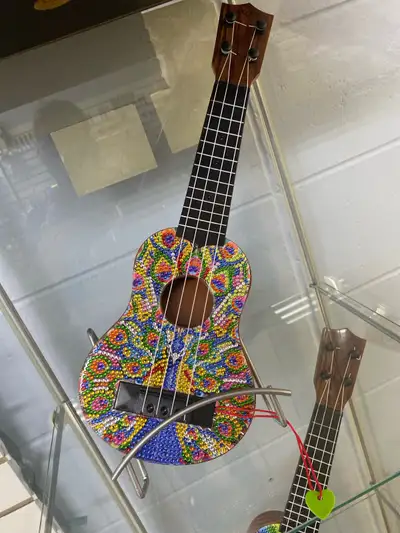 Ukulele diamond art all done up for someone to have . They are plastic and do work when played.