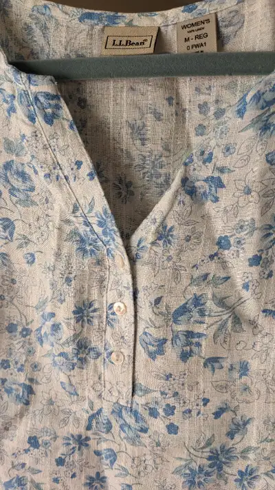 This lovely linen pullover with three shell buttons has a white on white vertical thread throughout...