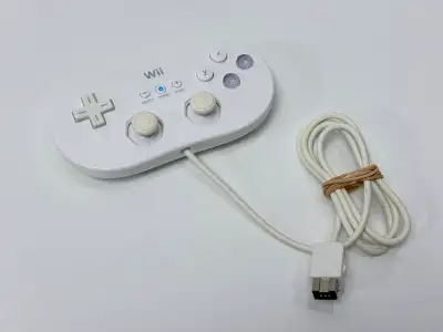 Official Nintendo Wii Classic Controller in white with attached wired cable. Features dual analog st...