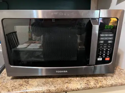 This is a used Toshiba microwave oven with a sleek stainless steel finish and user-friendly controls...