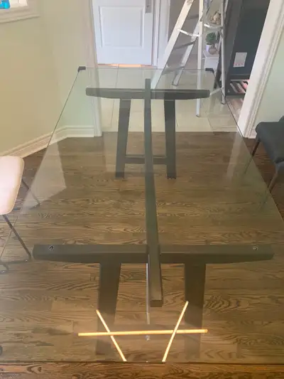 Modern structube dining room table with dark wood & metal base with glass table top. Some small scra...