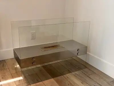 Enhance your living space with this modern glass and chrome indoor bioethanol fireplace, featuring a...
