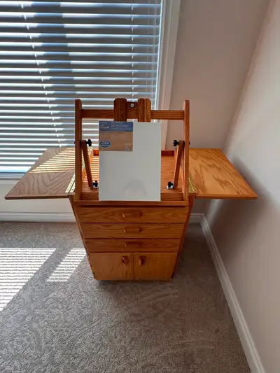 This versatile wooden art easel desk features a built-in easel, multiple storage drawers, and fold-o...