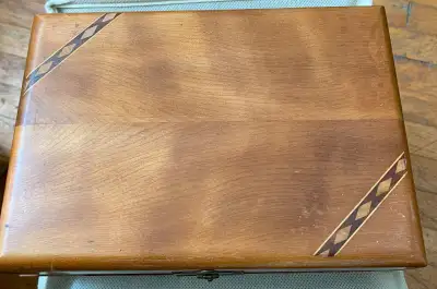 This vintage wood box has walnut inlay in the lid, brass hinges, a brass clasp, 4 wooden feet and do...