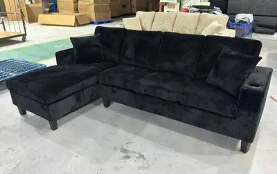 This brand new black corduroy sectional sofa features a sleek, modern design with built-in cup holde...