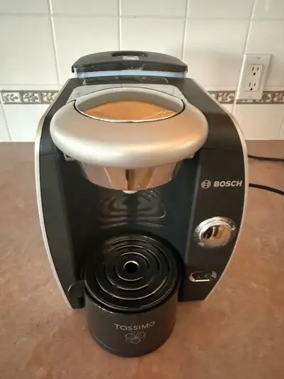 Brew your favourite beverages with this used Bosch Tassimo machine, perfect for coffee, tea, and hot...