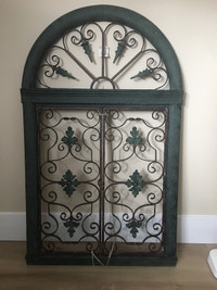 Garden or wall decor is an arched window with opening shutters