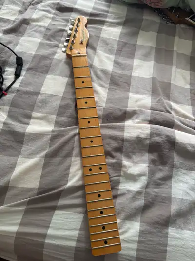 Maple guitar neck removed from a Squier Classic Vibe '60s Telecaster Thinline. There is visible dama...