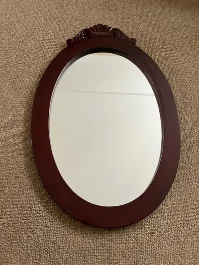 Brand new in box cherry wooden oval wall mirror. Has hangers in back. 29” x 19” Picture is a sample....