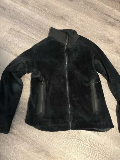 This is a Arc’teryx fleece jacket, providing warmth and comfort in a stylish black. It features a fu...