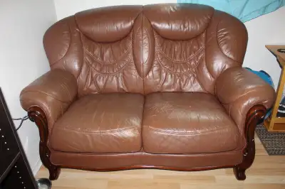 divan en cuir brun, un peu grafigné, confortable.