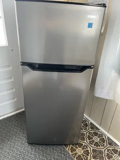 Petit réfrigérateur noir et inox avec congélateur de marque Danny 4.5 pied cube. En bon état. On l’a...