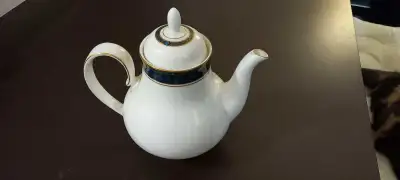 This elegant Royal Doulton teapot features a classic white ceramic body accented with a sophisticate...