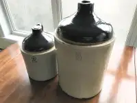 Antique 5 and 2 gallon clay jugs with handle.