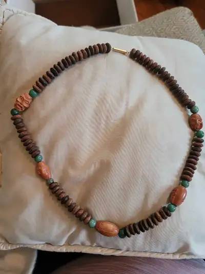 This unique wood and green stone necklace is a standout piece! The wood beads are interspersed with...
