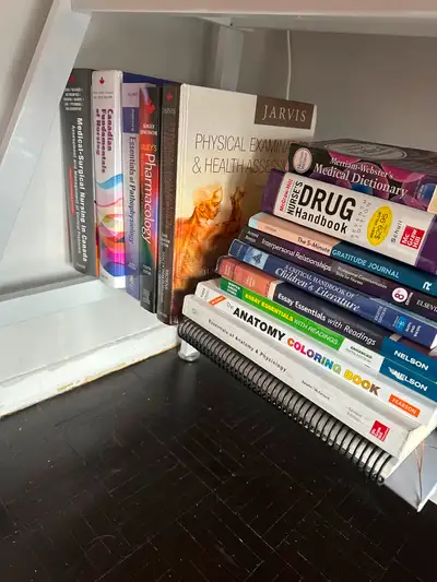Collection of nursing textbooks. Titles include Physical Examination & Health Assessment(sold), Phar...