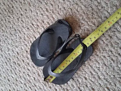 These are a pair of black flip flops, perfect for casual wear during the summer. Measurements shown...