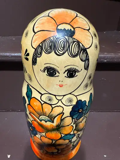 This charming Matryoshka doll, a traditional Russian nesting doll, features vibrant floral and portr...