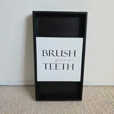 Add a touch of charm to your bathroom with this black bathroom shelf featuring a 'Brush Your Teeth'...