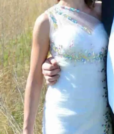 Mermaid fit white dress with pastels at base. Fits between about size 0 - 4. Corset back so size is...