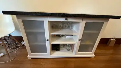 This used buffet table features a sleek black granite top and offers ample storage with two frosted...