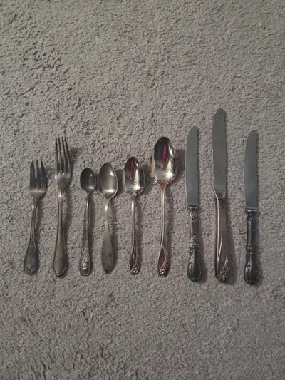 A curated collection of vintage silver-plated flatware from various premium makers. This 9-piece lot...