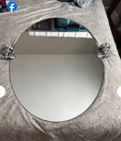 Oval Moen Glenshire mirror (pivots) with chrome mounting brackets. 31 Inch length x 21 inch width. W...