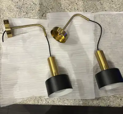 Wall lights never used. Gold and black. Can be wired but comes with a battery operated LED bulb with...