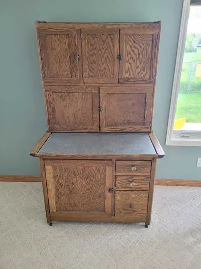 Vintage oak kitchen cabinet has a metal work surface and multiple storage compartments. This piece i...