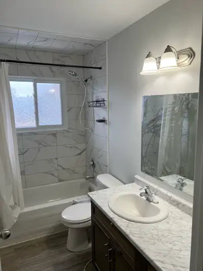 This bright and renovated 2-bedroom apartment features modern wood-style flooring throughout and a b...