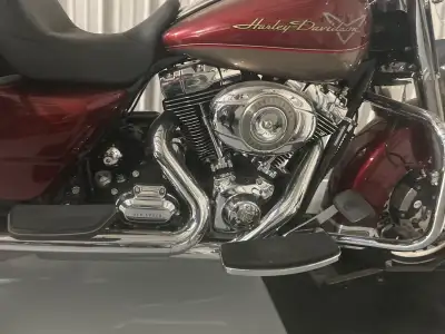 Feast your eyes on this stunning burgundy Harley Davidson, a true symbol of freedom and the open roa...