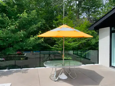 Table d'extérieur incluant parasol et base en ciment et couvre parasol