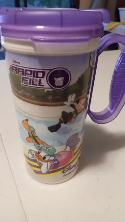 Disney Parks plastic travel mug featuring Mickey, Minnie, Donald, Daisy, Pluto and Goofy. Minor wear...